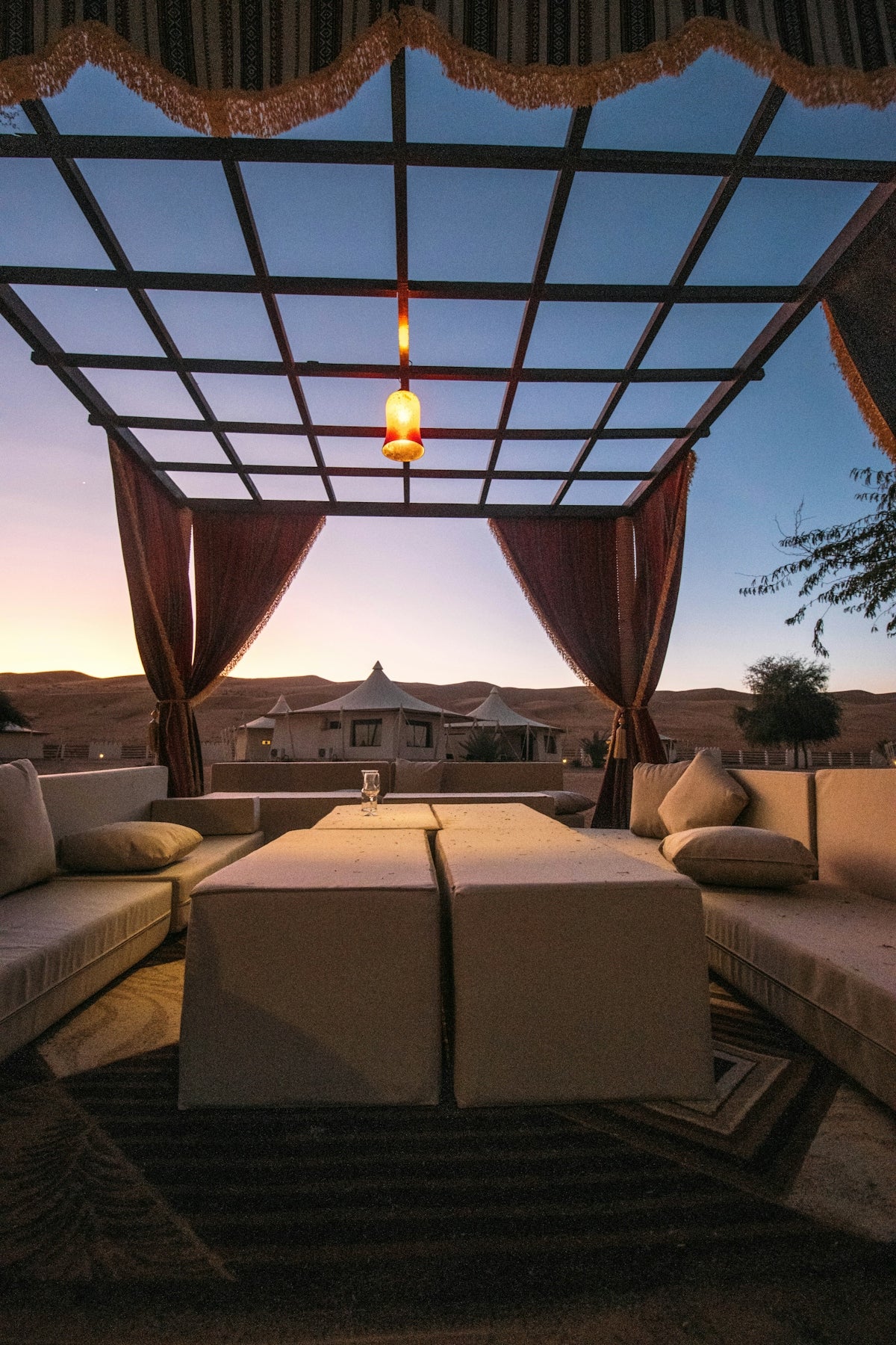 Luxurious outdoor lounge with a canopy and desert sunset