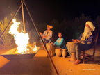 Traditional Moroccan men playing drums by a campfire at night on sandy ground during a 2-Day Tour from Marrakech