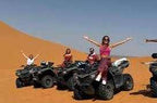2-Hour Merzouga Quad Bike riders on black quad bikes with desert orange sand dunes in the background, people celebrating adventure