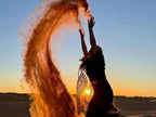 Silhouette of a person throwing golden sand into the air at sunset in a desert landscape, symbolizing the 3 Days Tour from Fes to Merzouga.