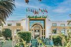 Agadir Beach Club Hotel white and beige facade with green signage, decorative fountains, and international flags above