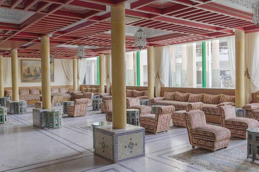 Spacious Moroccan-style lounge at Agadir Beach Club Hotel with patterned upholstered sofas, armchairs, and decorative pillars