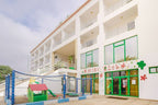 Agadir Beach Club Hotel white multi-story building with balconies and green-trimmed windows, featuring a colorful children's play area