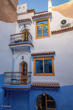 Alhambra Ryad & Spa exterior white and blue Moroccan riad with wooden framed windows, balconies, and terracotta roof tiles