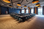 Barcelo Anfa Casablanca conference room with long table, teal chairs, dark patterned walls, and pendant lights