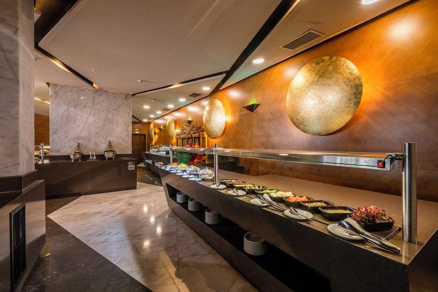 Barcelo Anfa Casablanca hotel buffet restaurant with modern wood walls, marble floors, and plated dishes