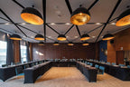 Barcelo Anfa Casablanca hotel conference room with black tables, teal chairs, wood walls, and pendant lighting