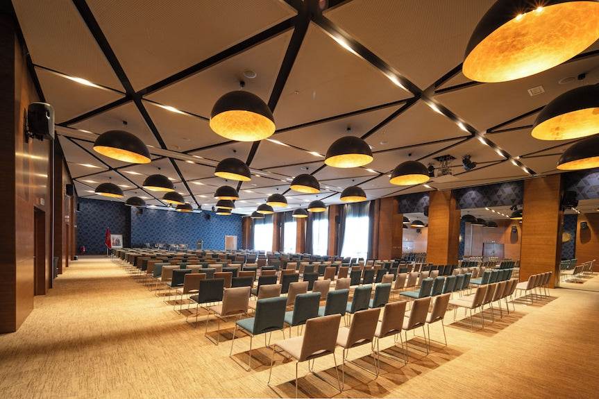 Barcelo Anfa Casablanca hotel conference room with rows of chairs, wood columns, and black pendant lights
