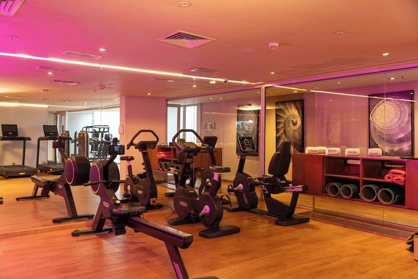 Barcelo Anfa Casablanca hotel gym with modern black cardio machines, weights, mirrors, and wooden flooring