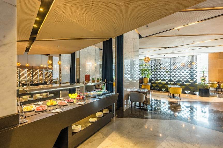Barcelo Anfa Casablanca hotel restaurant buffet with modern marble interior, plated dishes, fruit and elegant seating
