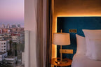 Barcelo Anfa Casablanca hotel room with blue upholstered headboard, white bedding, bedside lamp, and city view