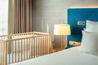Barcelo Anfa Casablanca hotel room with white bed, blue upholstered headboard, lamp, and wooden baby crib