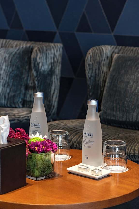 Barcelo Anfa Casablanca hotel table with bottled water, floral arrangement, glasses, and tissue box
