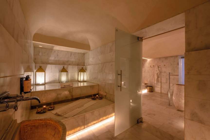 Barcelo Anfa Casablanca marble spa with a soaking pool, lanterns, tiled walls, and open glass door