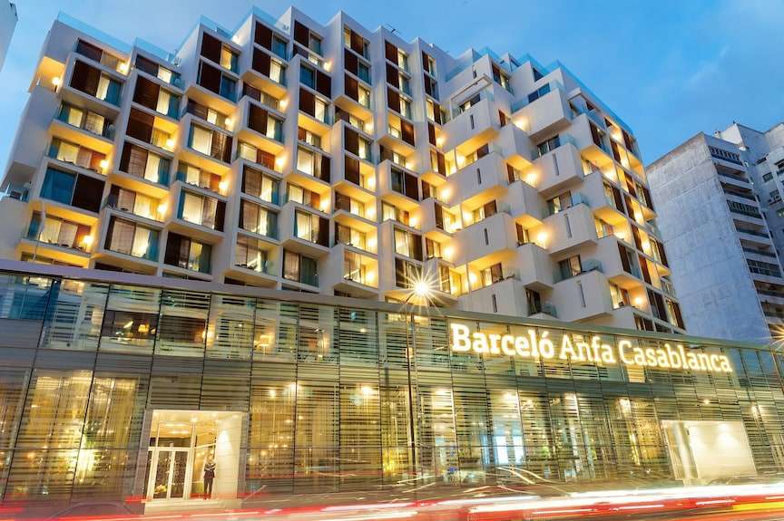 Barcelo Anfa Casablanca hotel with modern white balconies, illuminated windows, and glass-fronted entrance