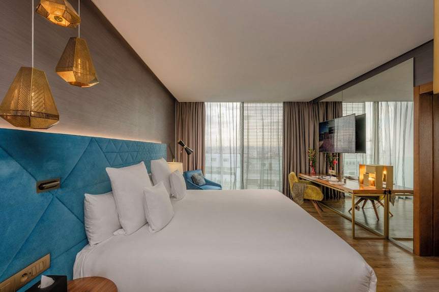 Barcelo Anfa Casablanca hotel room with white bed, blue upholstered headboard, and modern furnishings