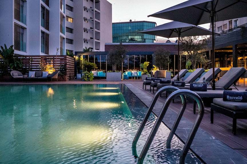 Barcelo Anfa Casablanca hotel outdoor pool with turquoise water, sun loungers, umbrellas and modern architecture