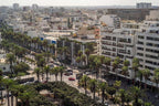 Barcelo Anfa Casablanca cityscape with palm-lined streets, dense urban buildings, and landscaped central park