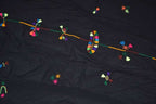 Black fabric scarf with colorful geometric and floral thread embroidery, showcasing traditional Berber Scarf Embroidery designs.