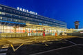 Airport terminal at Paris Orly with illuminated exterior glass facade and control tower at dusk, ideal for Book flight tickets