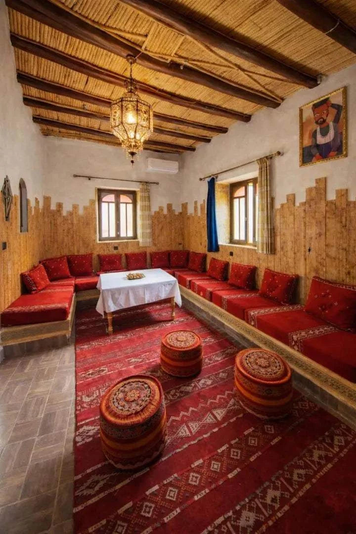 Casa Mona apartment spacious living room with red upholstered seating, patterned cushions, wooden ceiling, and traditional rugs