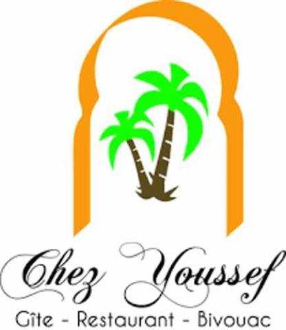 Logo of Chez Youssef Guesthouse featuring stylized brown and green palm trees framed by an orange arch symbolizing Moroccan hospitality