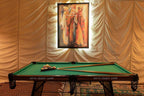 Dihya Desert Camp billiards table with green felt, wooden frame, pool cues, and colorful balls under a framed illuminated painting