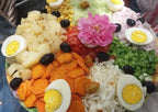 Erg Chigaga Star Camp colorful mixed vegetable salad with boiled eggs, black olives, and a pink flower garnish