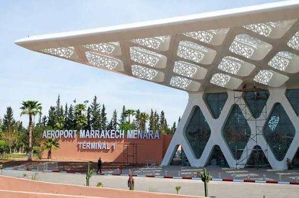 Modern outdoor view of Marrakech Menara Airport Terminal 1 with white geometric canopy and glass facade under clear sky