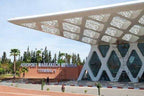 Modern outdoor view of Marrakech Menara Airport Terminal 1 with white geometric canopy and glass facade under clear sky