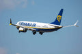 Ryanair commercial passenger airplane with white and blue color scheme flying against a clear sky, promoting flight tickets to Errachidia