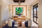Four Seasons Resort Marrakech elegant office space with wooden desk, blue and white velvet chairs, patterned rug, and vibrant leaf art