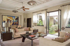 Four Seasons Resort Marrakech living room with beige sofas, dark wood coffee table, colorful cushions, and bright natural light