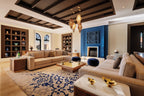 Luxury living room with beige sectional sofas, blue and beige patterned rug, blue fireplace, and Moroccan lanterns at Four Seasons Resort Marrakech