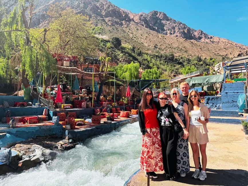 From Marrakech to Ourika Valley tour showing five women beside a rushing river with mountain scenery