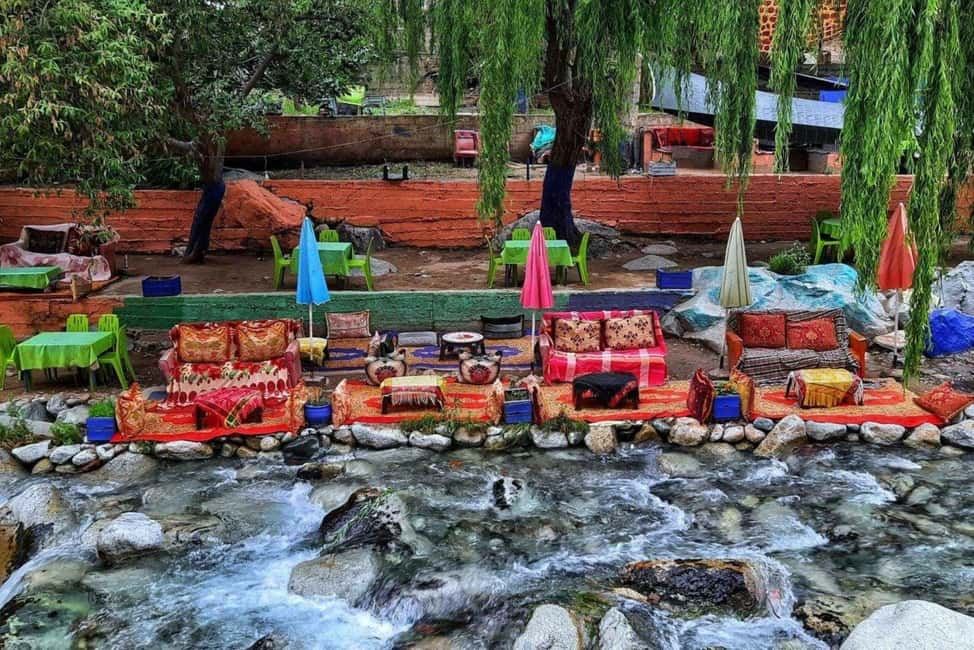 From Marrakech to Ourika Valley tour with colourful Moroccan seating beside a clear rocky river