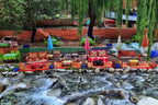 From Marrakech to Ourika Valley tour with colourful Moroccan seating beside a clear rocky river