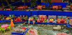 From Marrakech to Ourika Valley tour showing colourful riverside cushions, tables, umbrellas and flowing mountain stream