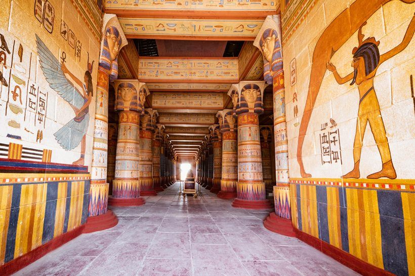 From Marrakech: To Sahara Tour showing an Egyptian-style temple corridor with painted columns, hieroglyphs and wall figures