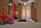 Hassilabiad Appart Hotel elegant room detail with red decorative vase and pink flowers on beige textured surface