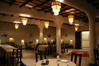 Hotel Kasbah Ksar Bicha interior with warm lighting, wooden ceiling, beige walls, and traditional carpeted floor
