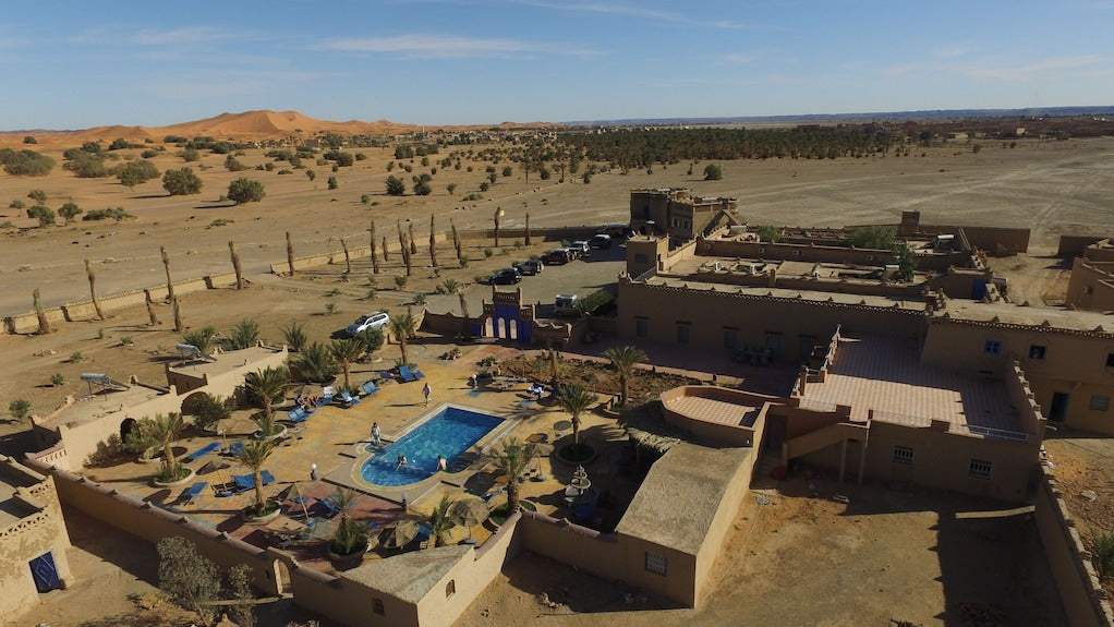 Hotel Kasbah Ksar Bicha with traditional kasbah architecture and courtyard swimming pool set in arid desert landscape