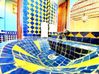 Hotel Ksar Merzouga bathroom sink with blue and yellow geometric patterned ceramic tiles and a modern faucet