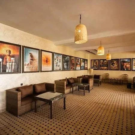 Hotel Nomad Palace cozy seating area with brown wicker sofas, glass tables, framed wall art, and hanging woven lamps
