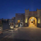 Hotel Nomad Palace entrance at night with illuminated lanterns and traditional Moroccan architectural features