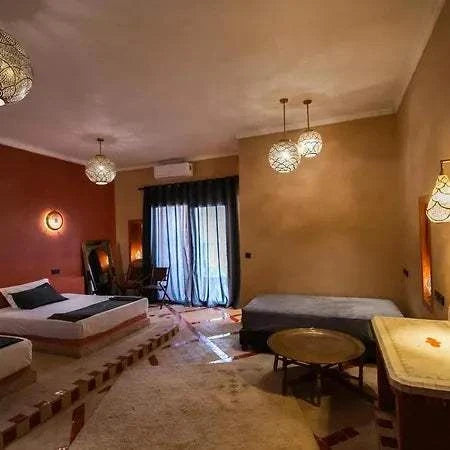 Hotel Nomad Palace spacious guest room with warm earth tones, twin beds, Moroccan-style lighting, and cozy seating area