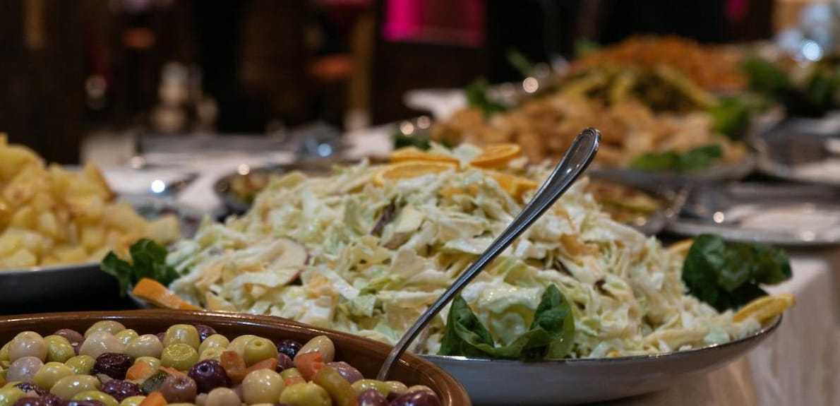 Hotel Yasmina Merzouga buffet featuring a variety of fresh salads with creamy dressing and bowl of mixed olives
