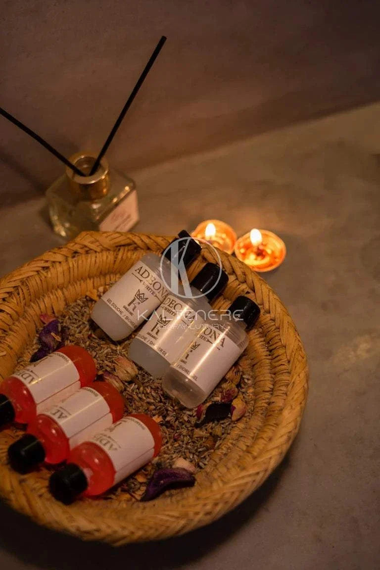 Kal Tenere Agafay luxury camp toiletries kit with white and red bottles arranged in a woven basket with decorative potpourri and candles