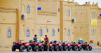Kasbah Hotel Bar with beige traditional mud-brick architecture and a row of red all-terrain vehicles lined up outside