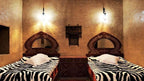 Kasbah Hotel Bar room with traditional Moroccan earthy walls, wooden headboards, and zebra pattern bed covers